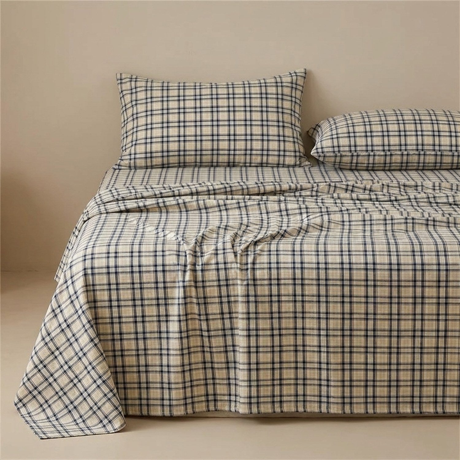 Drap plat carreaux marine en coton fait sur un lit avec oreillers assortis