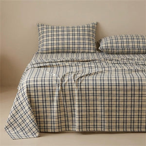 Drap plat carreaux marine en coton fait sur un lit avec oreillers assortis
