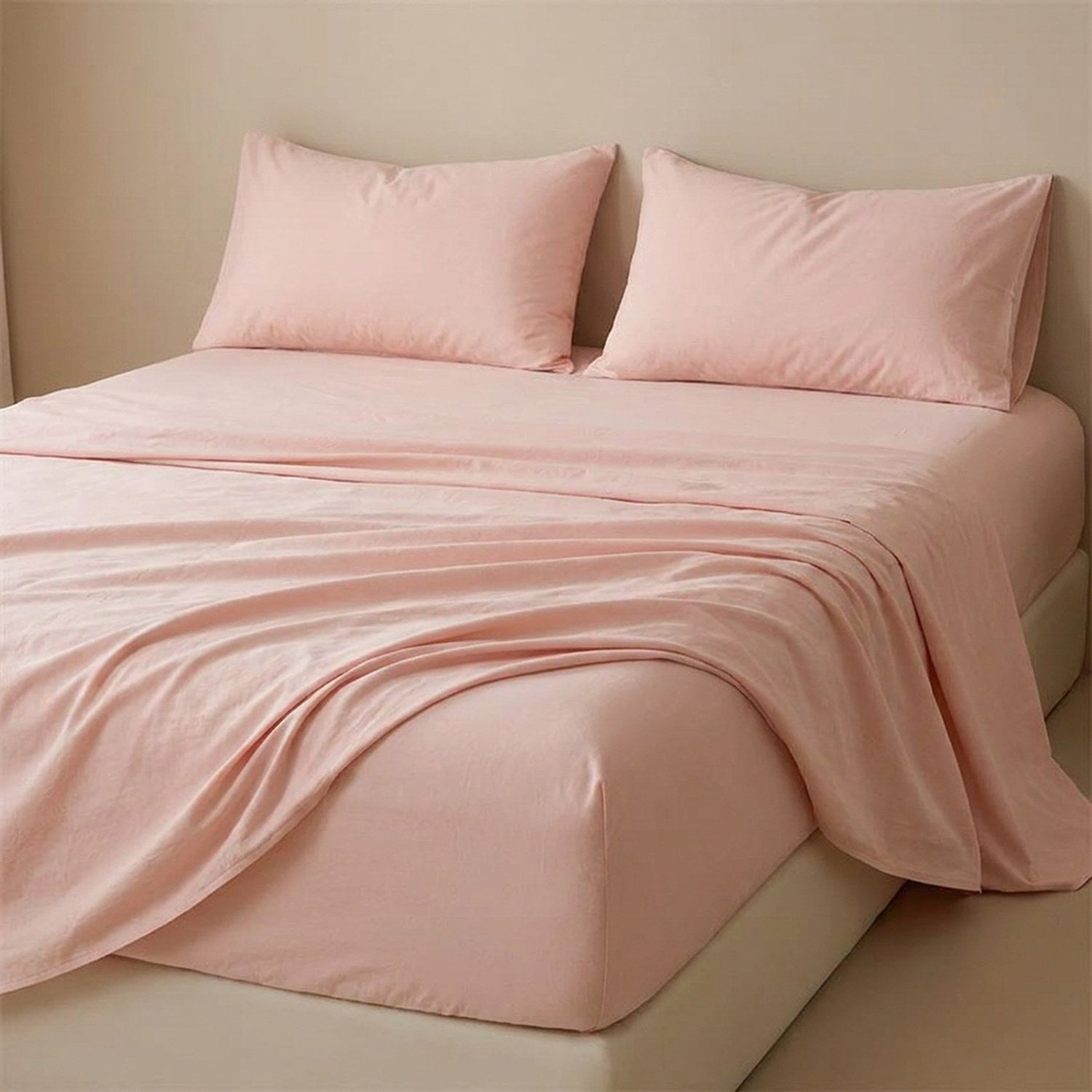 Drap plat rose poudré en coton fait sur un lit avec oreillers assortis