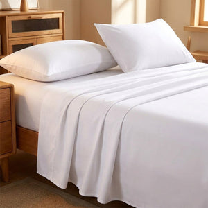 Drap plat blanc en coton doux posé sur un lit avec oreillers blancs moelleux