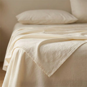 Drap plat en coton blanche plié en pointe sur un lit avec oreiller