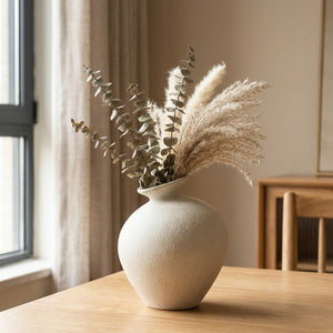 Vase en céramique imitation pierre style rétro avec branches séchées sur surface bois