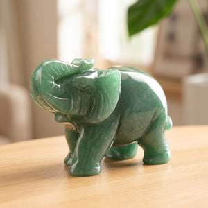 Figurine éléphant en aventurine verte sculptée posée sur une surface en bois