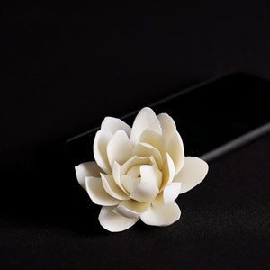 Brûleur d'encens fleur céramique blanche sur fond sombre élégant