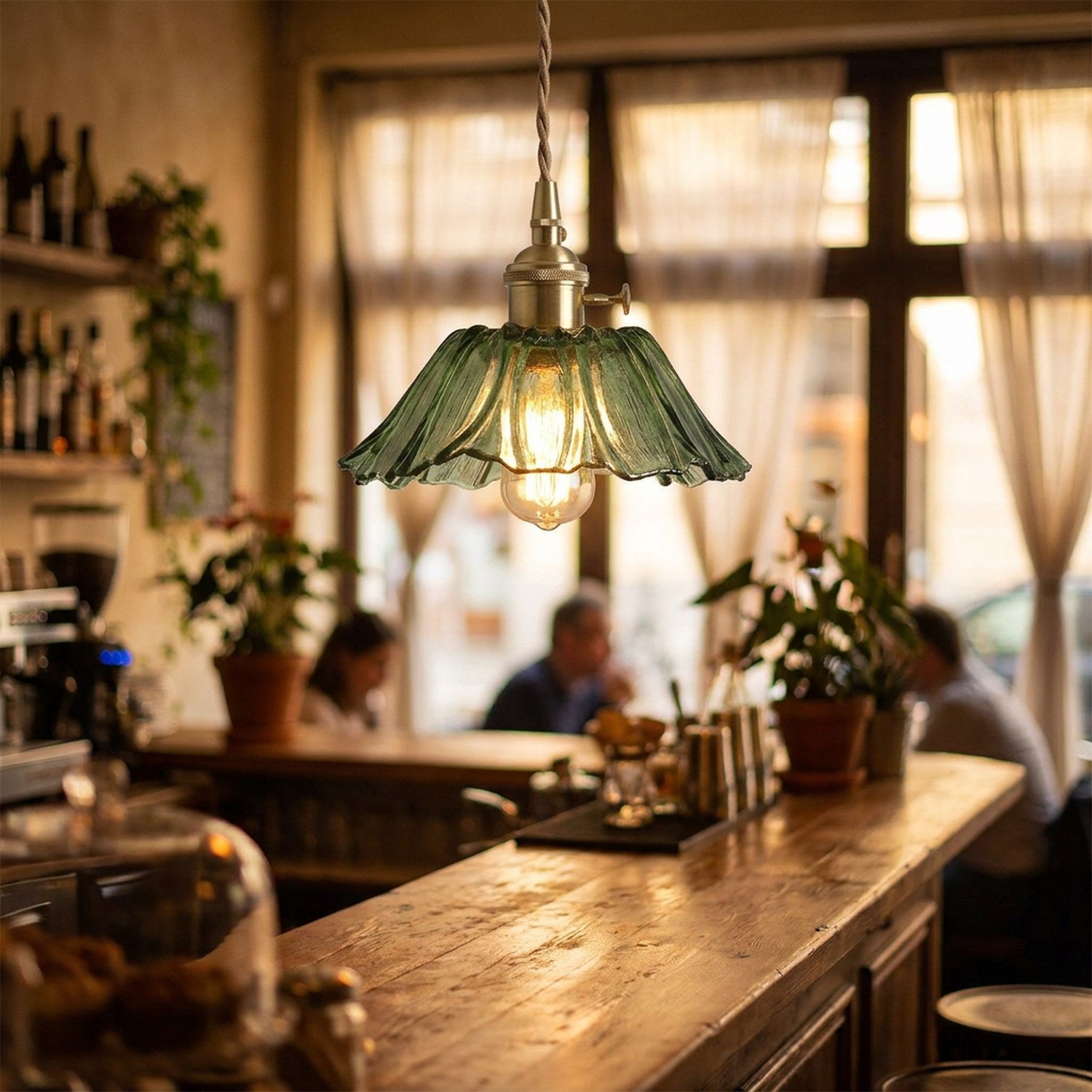 Suspension en verre vert petite fleur 19cm dans un bistrot chaleureux au-dessus d'un comptoir en bois