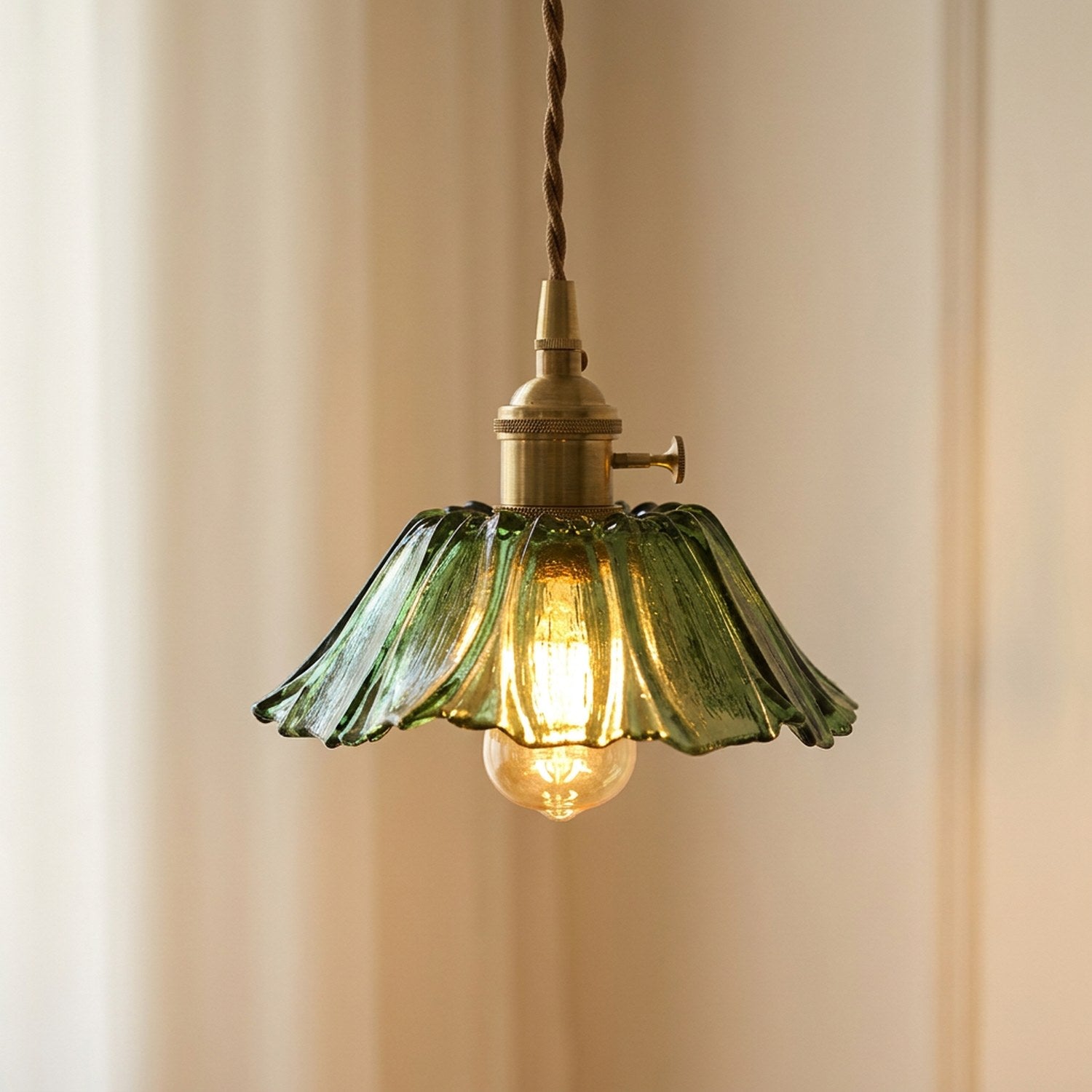 Suspension petite fleur en verre vert allumée, cordon tressé et support laiton