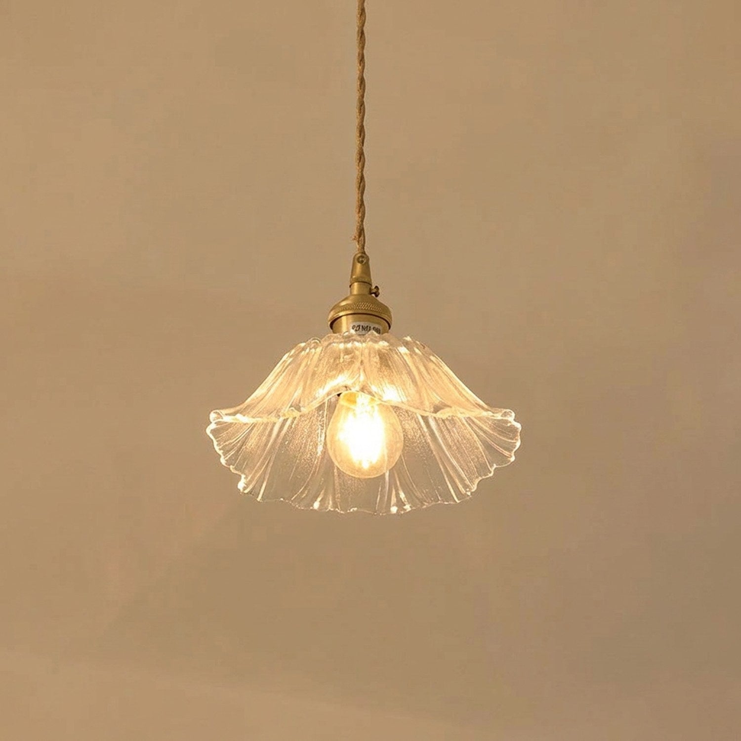 Suspension petite fleur en verre transparent allumée, cordon tressé et support laiton