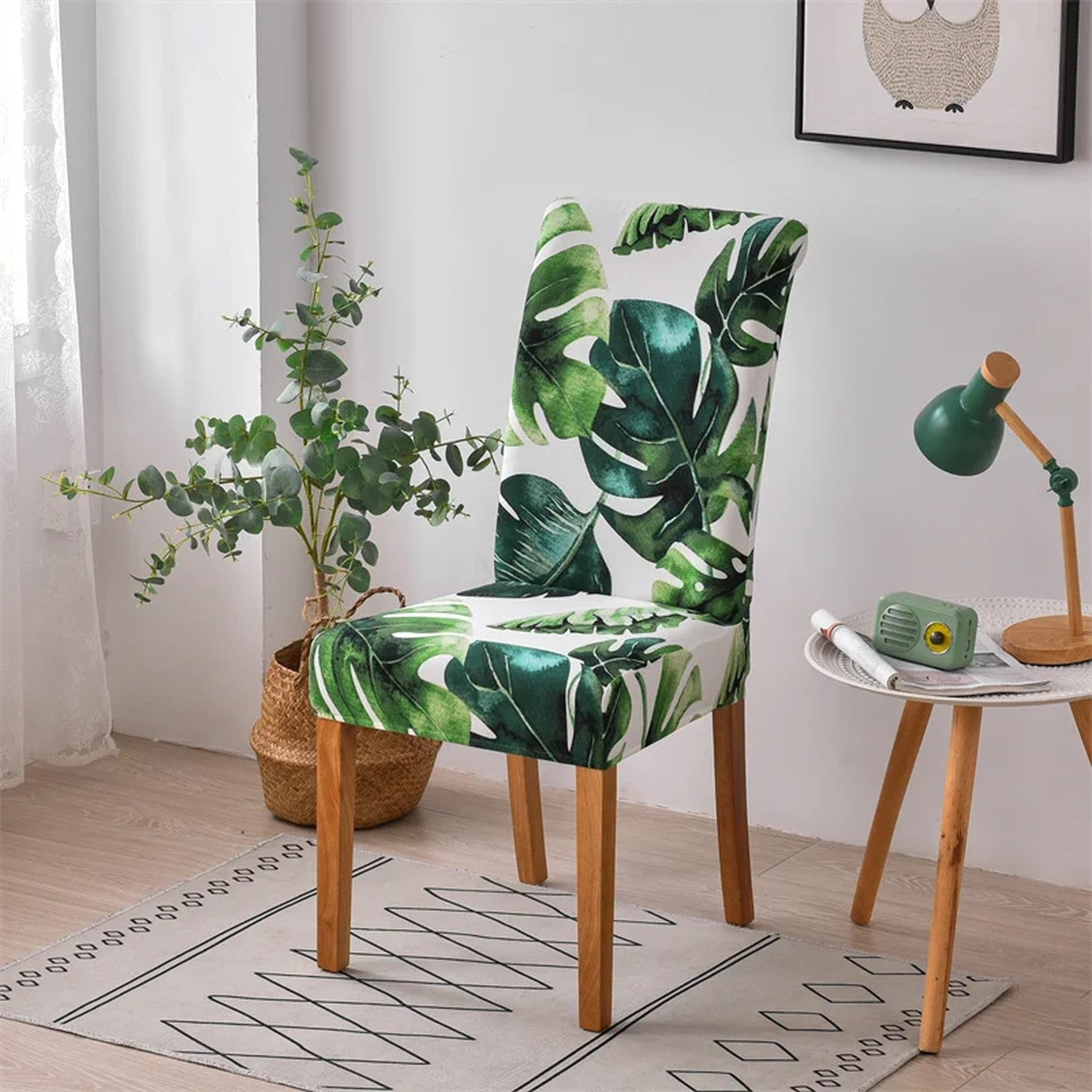 Housse de chaise extensible à feuillage tropical vert sur une chaise de salle à manger