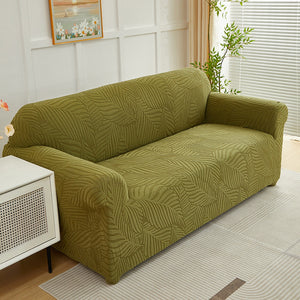 Housse de canapé motif feuilles verte installée sur un canapé