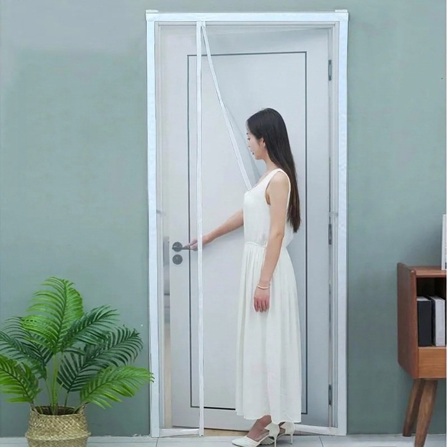 Femme ouvrant une moustiquaire magnétique blanche fixée sur une porte