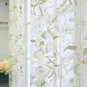 Motif floral vert sur tulle transparent avec fruits et feuillage délicat