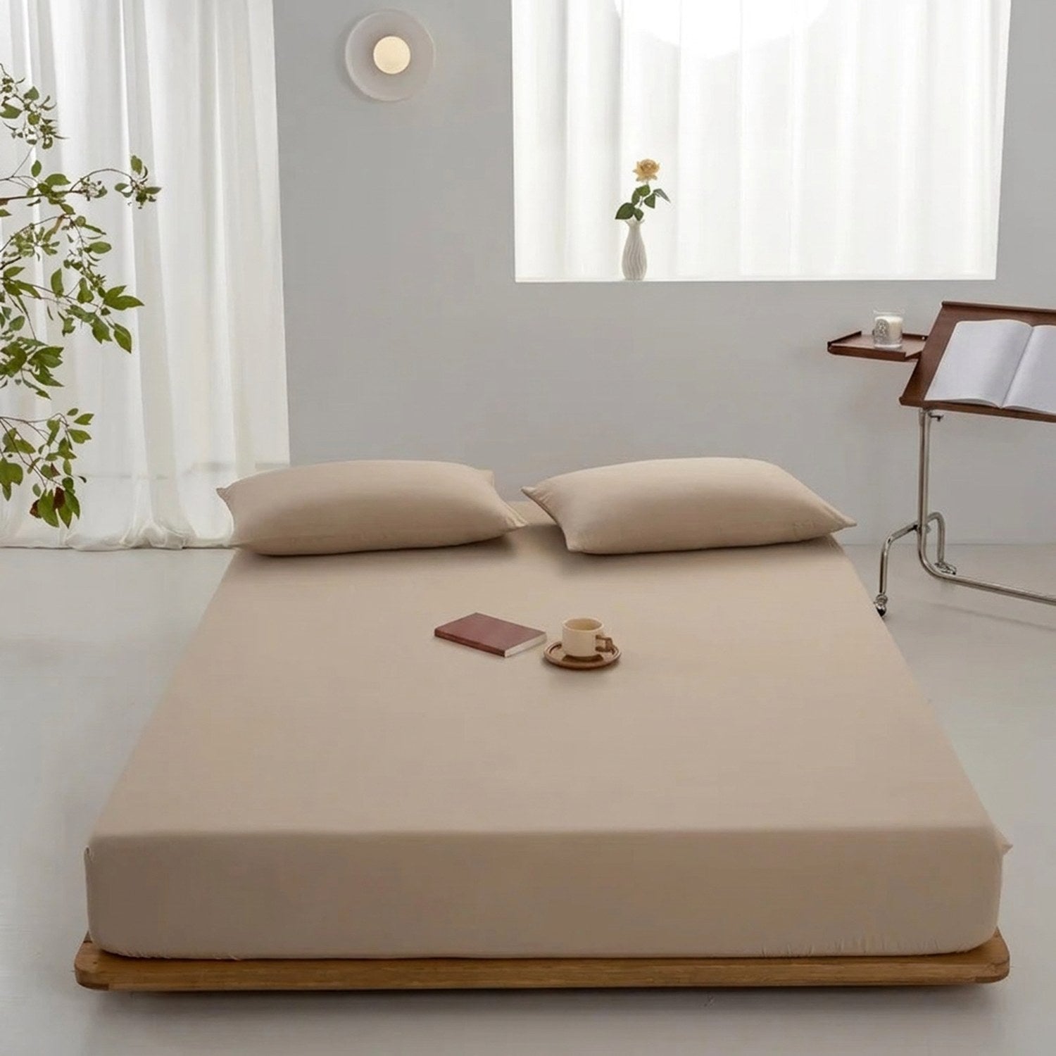 Drap-housse beige installé sur un lit dans une chambre chaleureuse