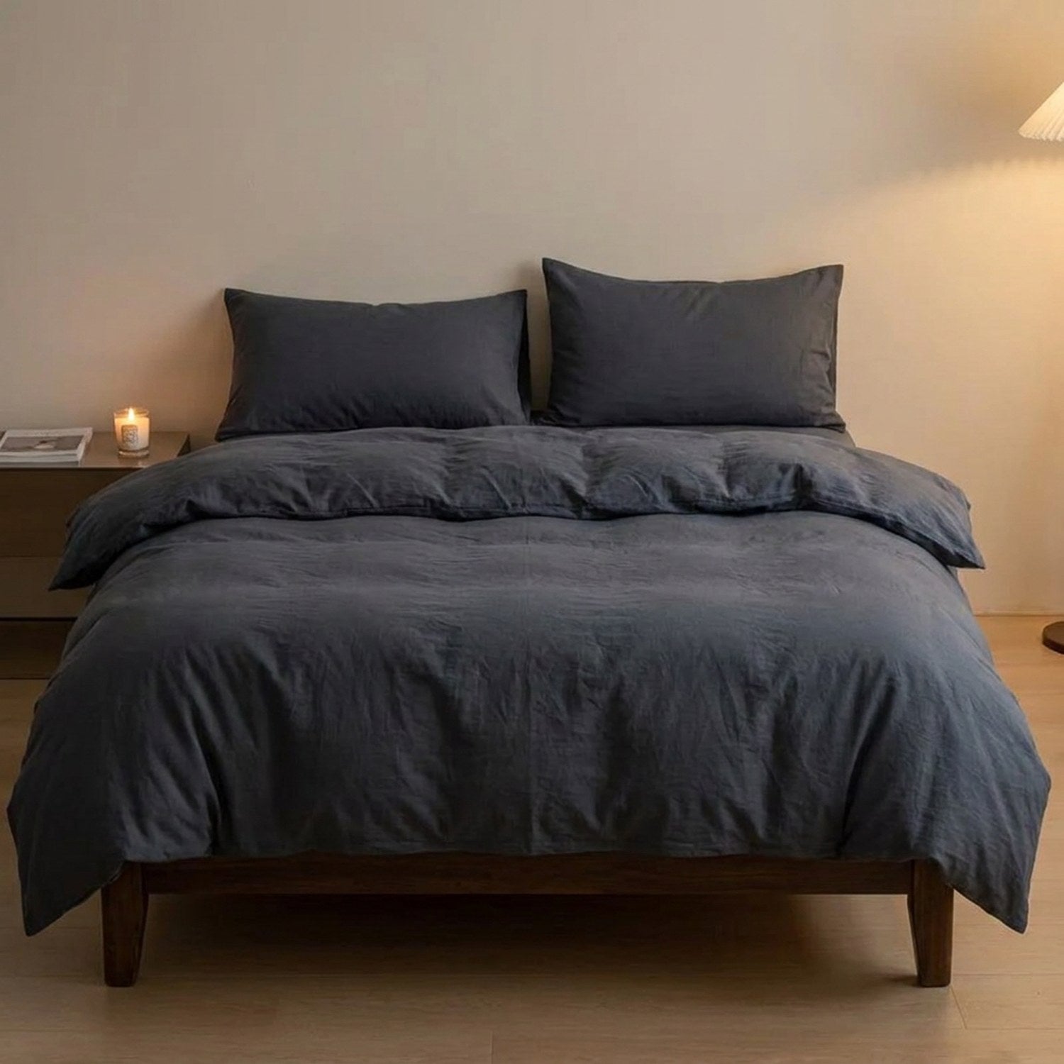 Parure de lit unie gris foncé posée sur un lit dans une chambre moderne épurée