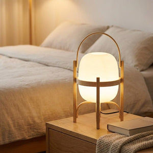 Lampe lanterne en bois allumee sur une table de chevet dans une chambre chaleureuse