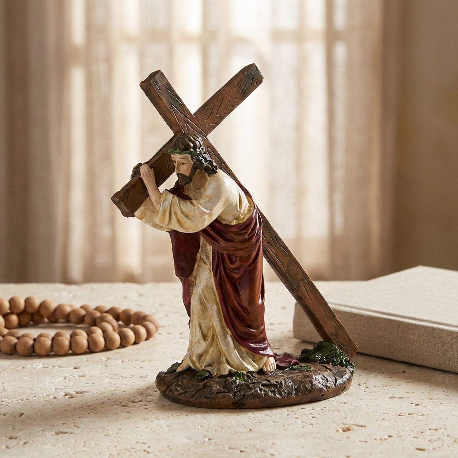 Statue de Jésus portant la croix près d'une fenêtre avec un chapelet en bois