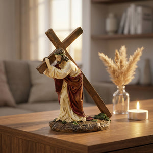 Statue de Jésus portant la croix sur une console en noyer avec une bougie allumée
