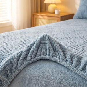 Coin replié d'un drap-housse bleu pâle en peluche gaufrée montrant l'élastique