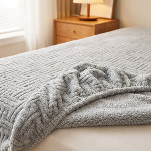 Coin replié d'un drap-housse gris en peluche gaufrée montrant l'élastique