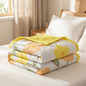 Couvre-lit matelassé d'été motif fleurs jaunes plié sur un lit