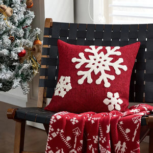 Housse de coussin rouge brodée de flocons blancs sur chaise en bois