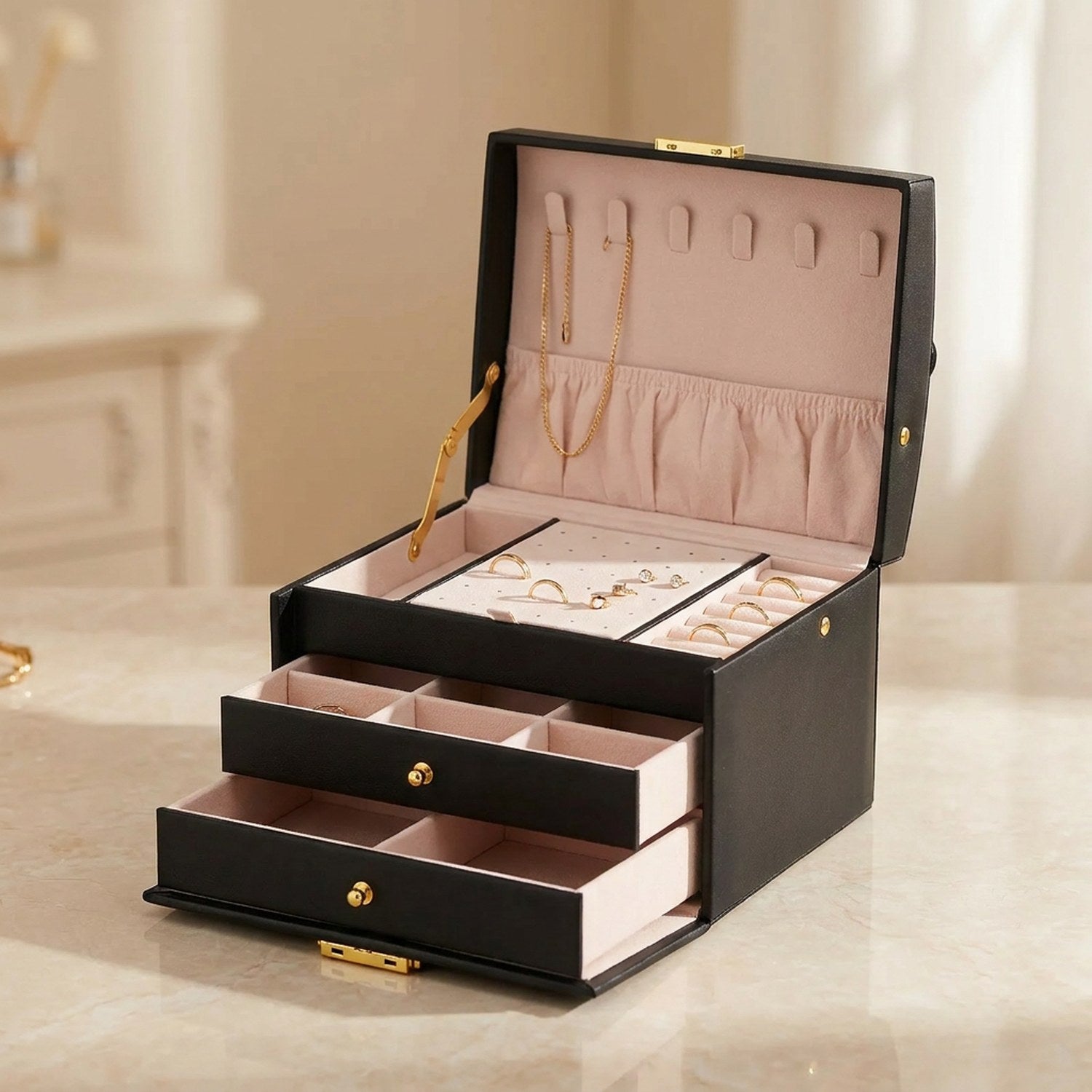 Boîte à bijoux à trois niveaux en simili cuir noir ouverte avec serrure dorée