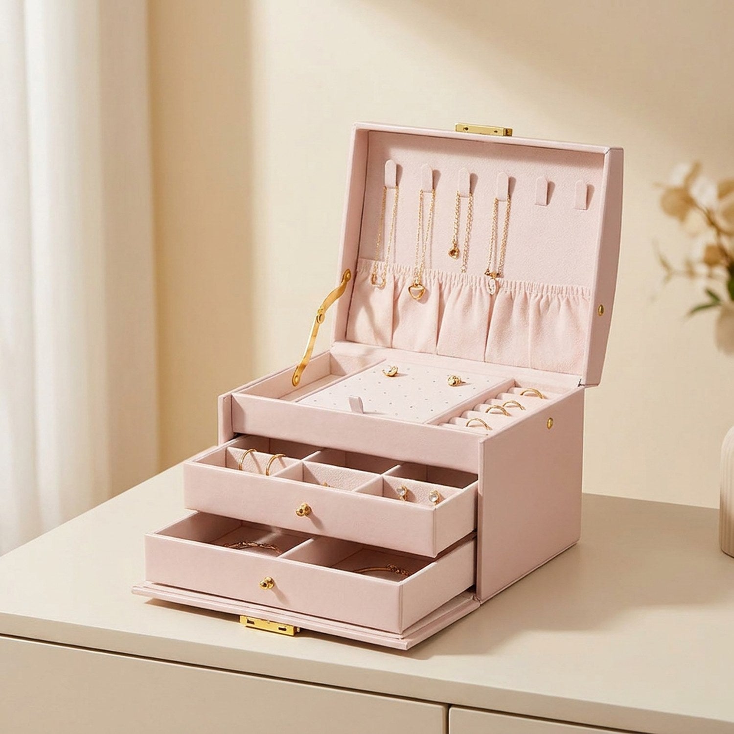 Boîte à bijoux à trois niveaux en simili cuir rose ouverte avec serrure dorée