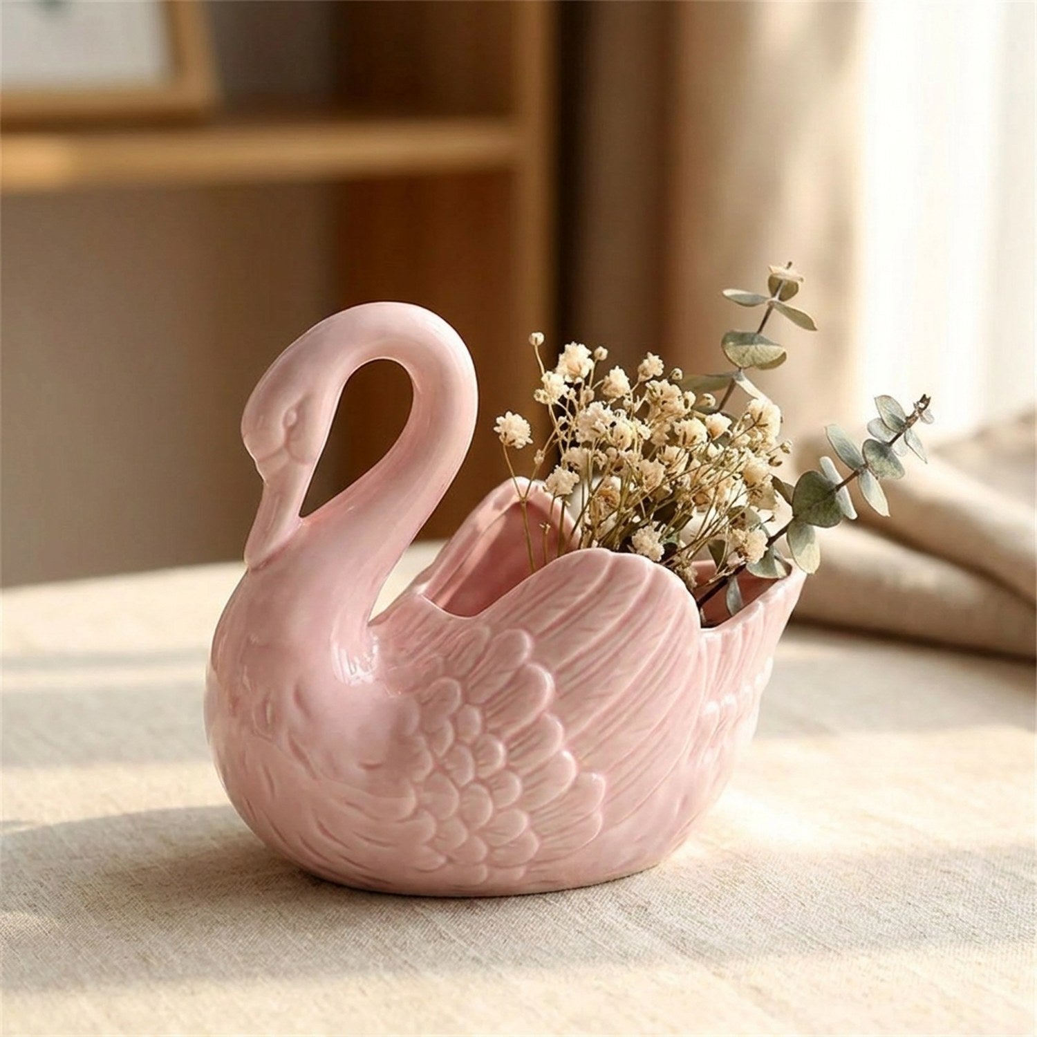 Vase cygne en céramique rose garni de fleurs séchées et eucalyptus