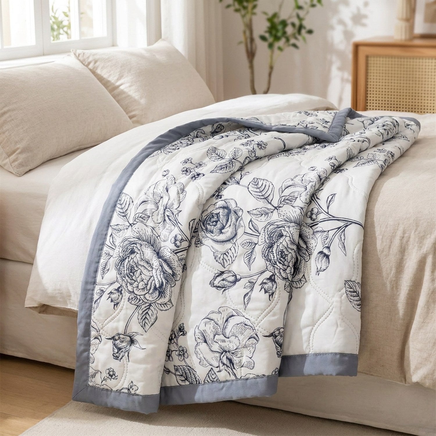 Couette d'été en coton lavé à roses noires pliée sur un lit