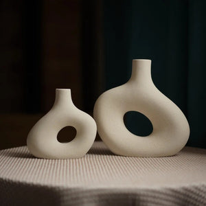 Petit et grand vase en céramique donut blanc cassé posés côte à côte