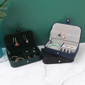 Boîtes à bijoux voyage verte et bleue ouvertes sur surface en marbre