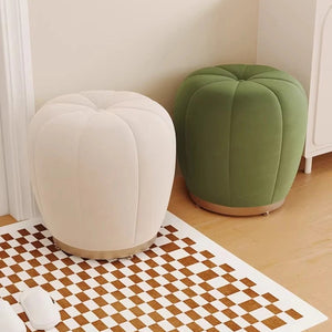 Pouf tabouret citrouille crème et vert côte à côte sur un tapis damier