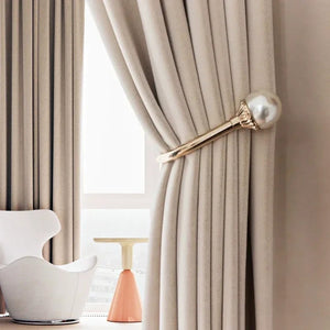 Rideau occultant en velours beige avec attache perle devant une fenêtre de salon