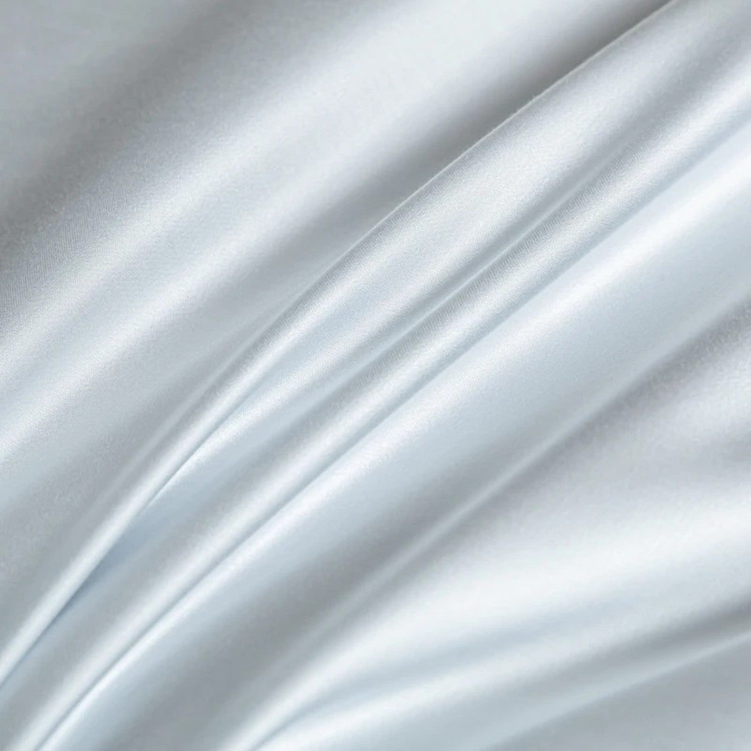 Gros plan sur le tissu soyeux en soie glacée de la couette d'été