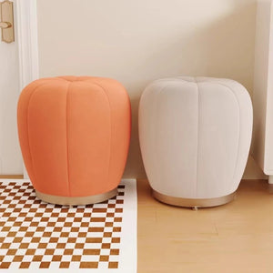 Pouf tabouret citrouille orange et crème côte à côte près d'une porte