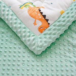 Gros plan sur le tissu moelleux et le motif dinosaures de la couette bébé