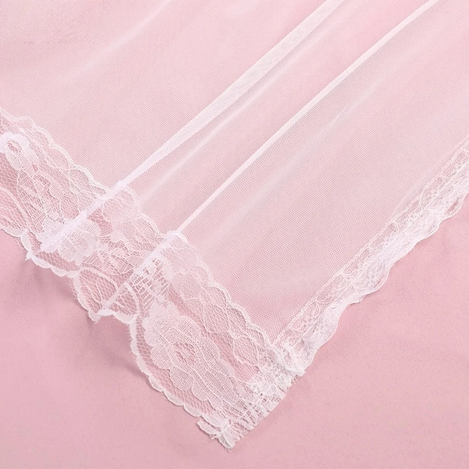 Détail de la bordure en dentelle du voile rose poudré