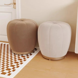 Pouf tabouret citrouille beige et crème côte à côte sur un tapis damier