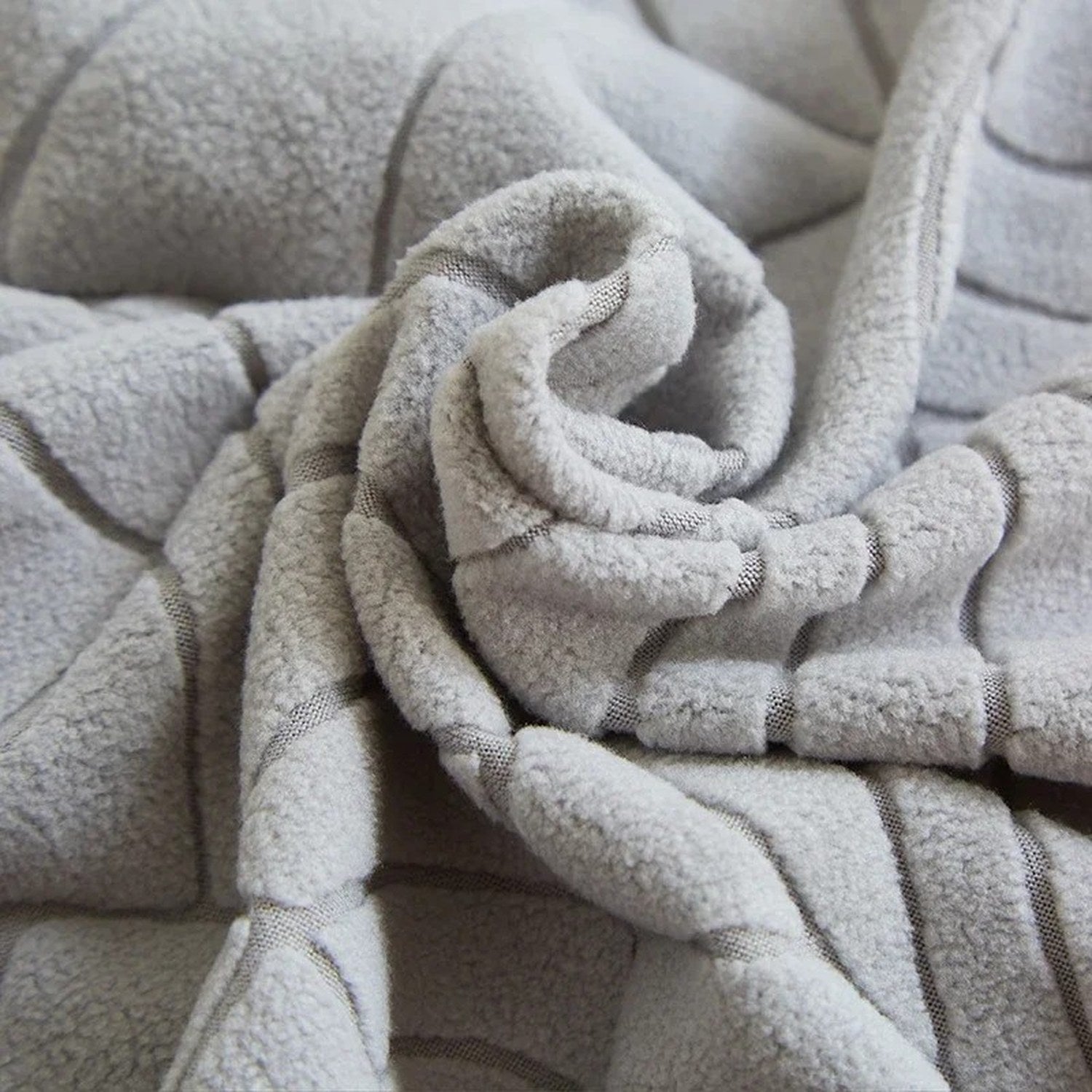 Gros plan sur la texture matelassée du tissu de la housse de fauteuil