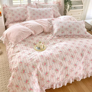 Parure de lit fleurie rose posée sur un lit avec coussin à carreaux