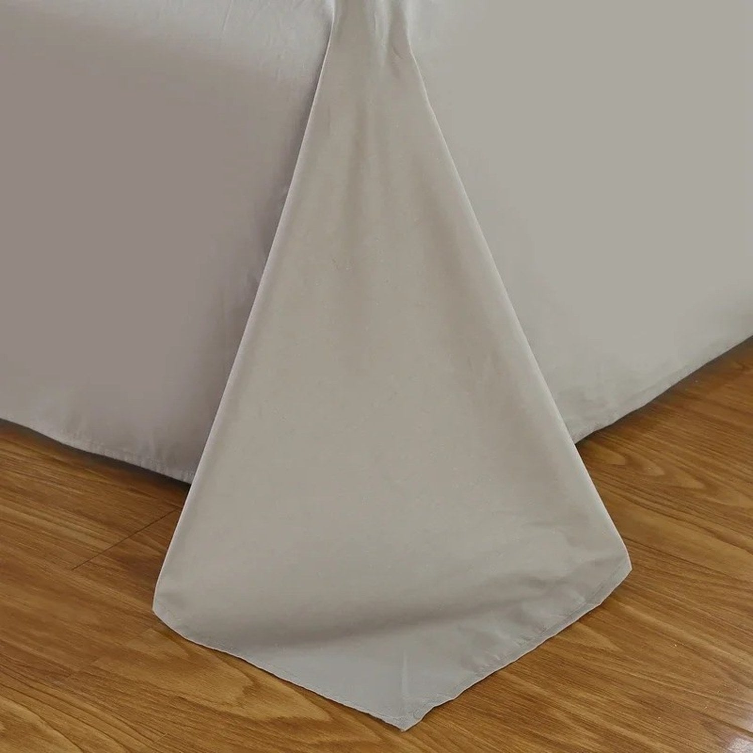 Détail du tissu du drap plat en coton replié au pied du lit
