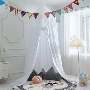 Moustiquaire dôme blanche suspendue avec fanions colorés au-dessus d'un tapis de jeu