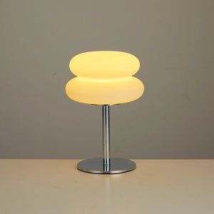 Lampe de chevet champignon allumée en lumière chaude sur fond neutre