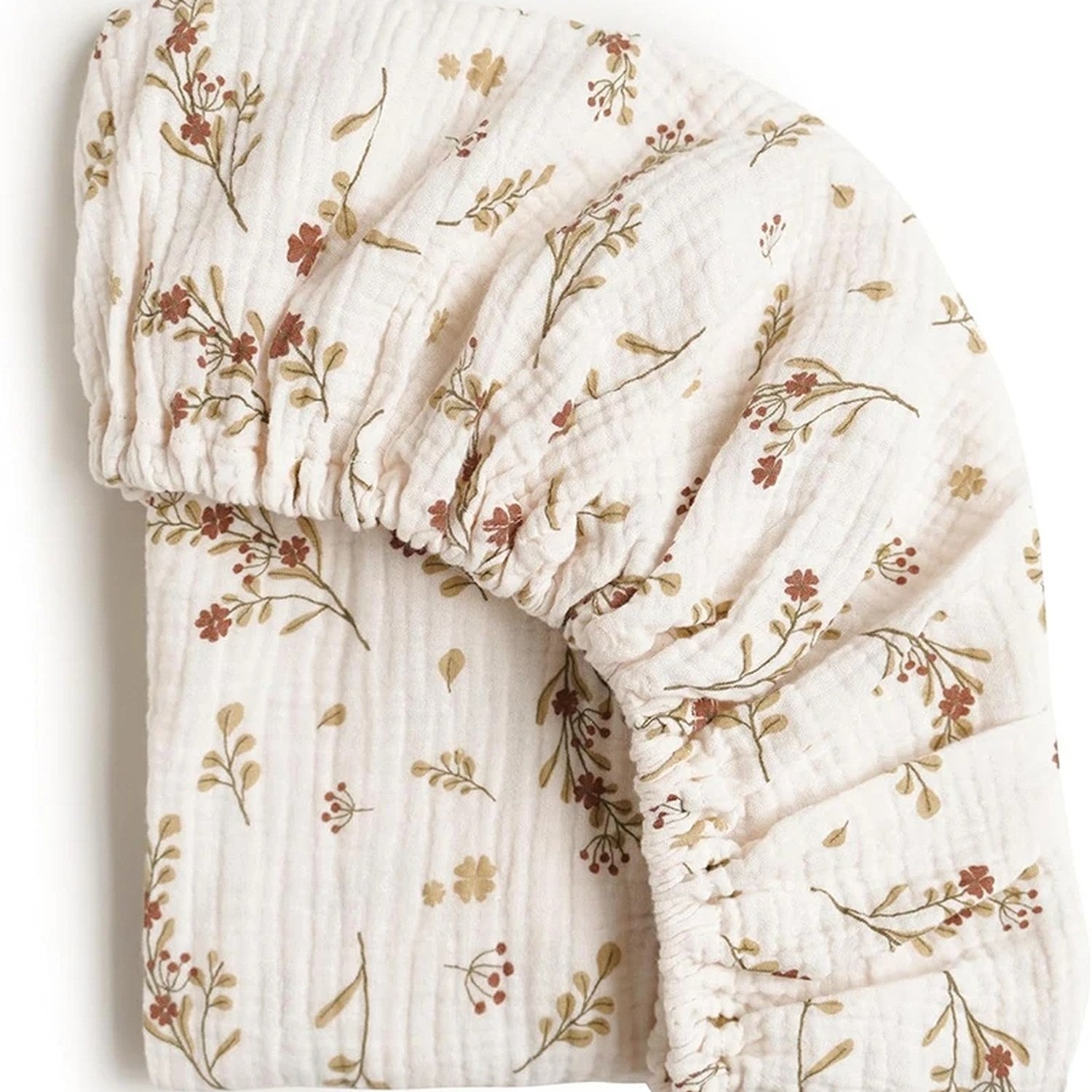 Gros plan sur le tissu en gaze de coton froissée d un drap-housse de berceau à fleurs terracotta