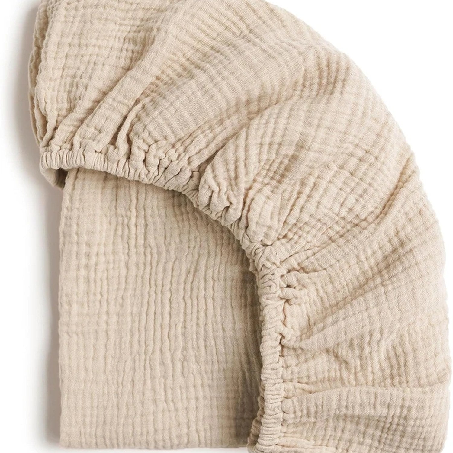 Deux draps-housses de berceau en gaze de coton unie beige pliés l un sur l autre