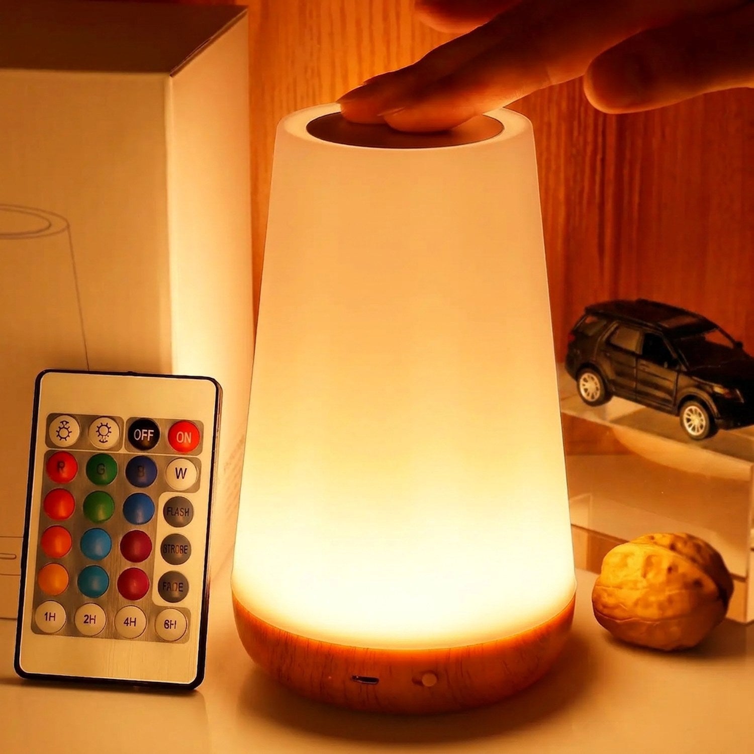 Lampe tactile allumée avec télécommande 13 couleurs près d'une lampe en bois