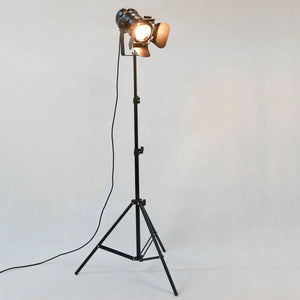 Lampadaire trépied projecteur noir fond gris référence