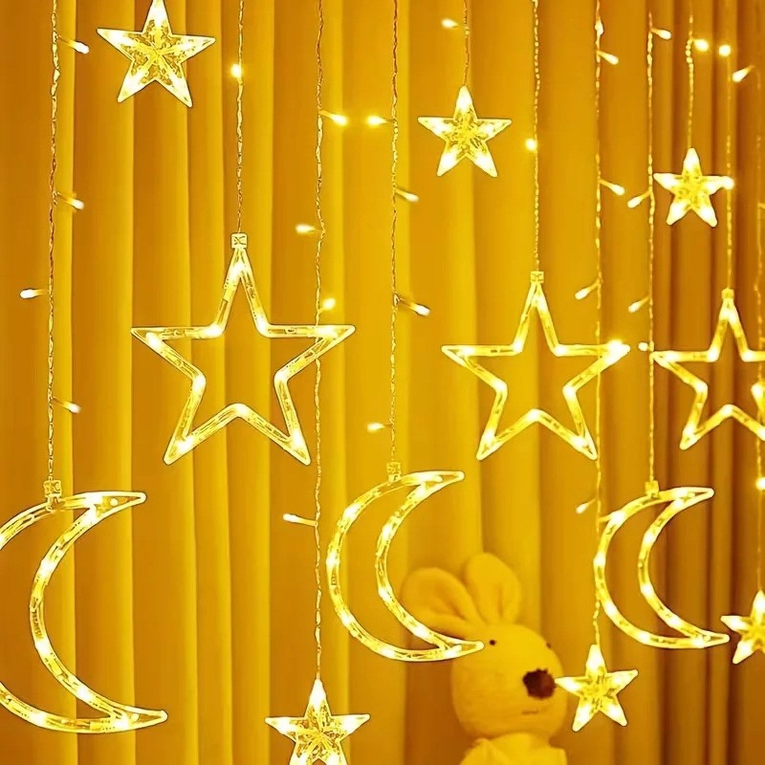 Guirlande lumineuse LED étoile et lune éclairage blanc chaud devant rideau jaune