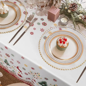 Gros plan d'une table de fête dressée avec assiettes blanches et petites douceurs de Noël