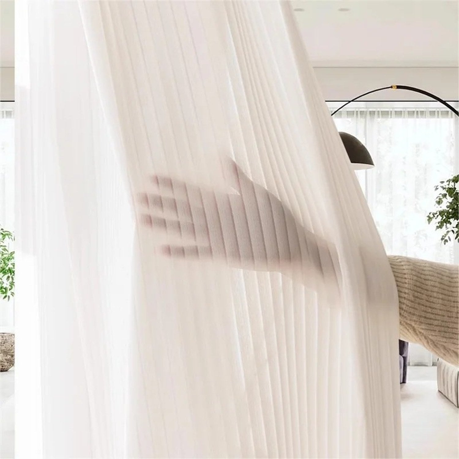 Rideau voilage blanc à rayures suspendu dans un salon lumineux avec plantes vertes
