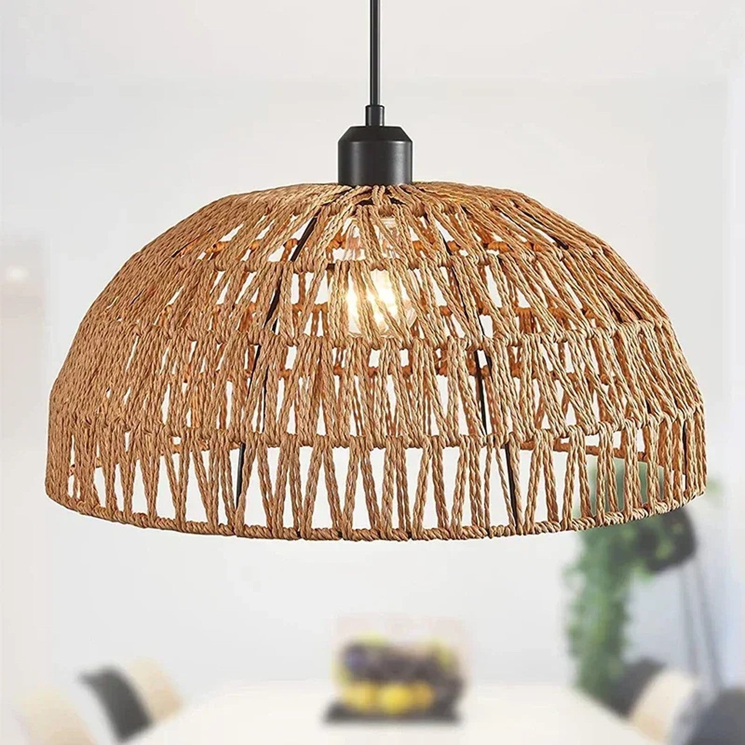 Suspension dôme en corde naturelle beige allumée au-dessus d une table à manger